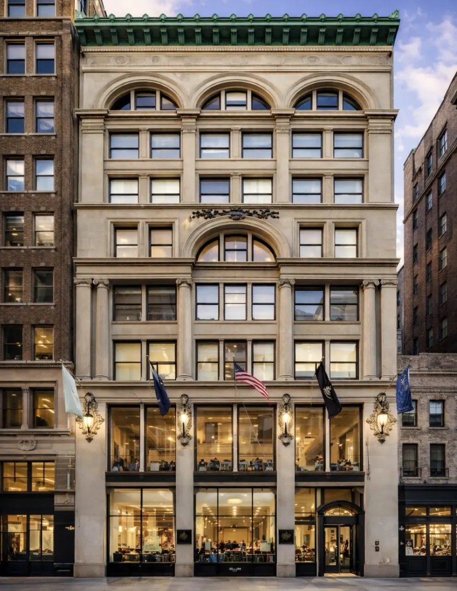 43 West 23rd Street, a cream limestone building with arched windows, a green copper cornice and flags above the entrance