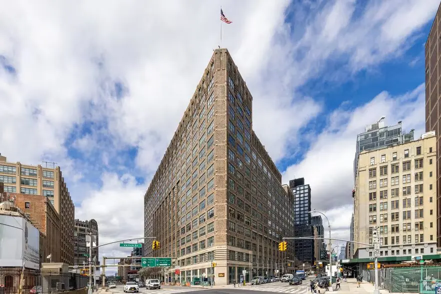 75 Varick Street, a tall tan-brick building with a flagpole at its peak